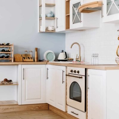 Modern white kitchen with wooden accents and minimalist design elements.